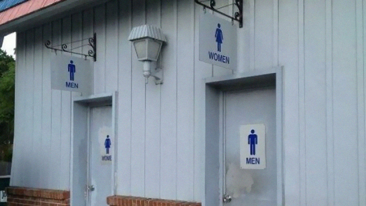 Bathroom doors with signs placed incorrectly, showing poor job performance that is almost impressive.