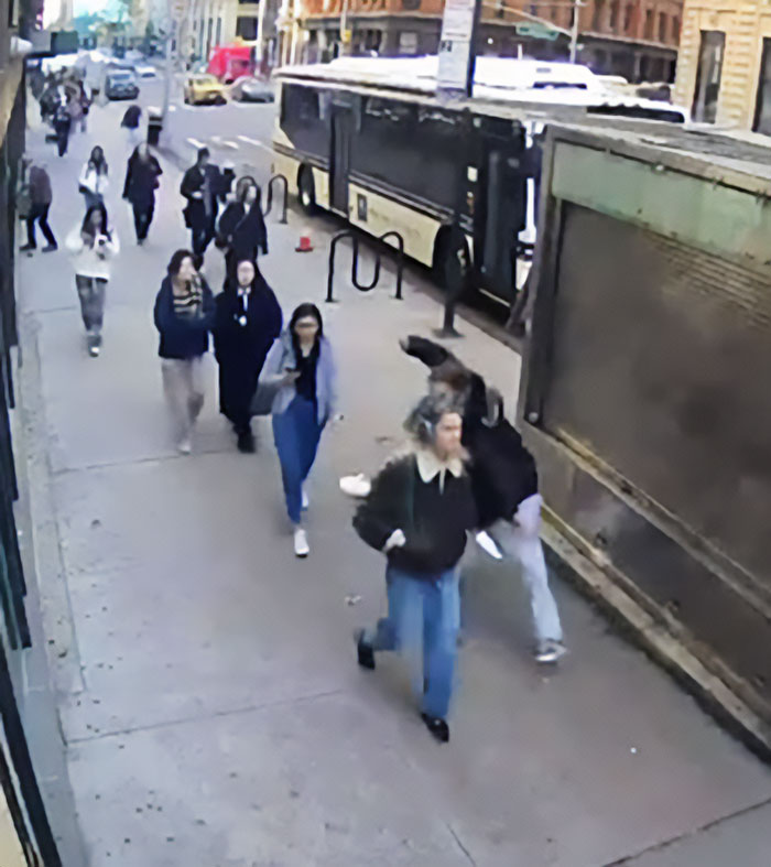 Pedestrians walking on a city sidewalk captured in viral video exposing serial creep after NYU shove incident. Pedestrians walking on a city sidewalk captured in viral video exposing serial creep after NYU shove incident.