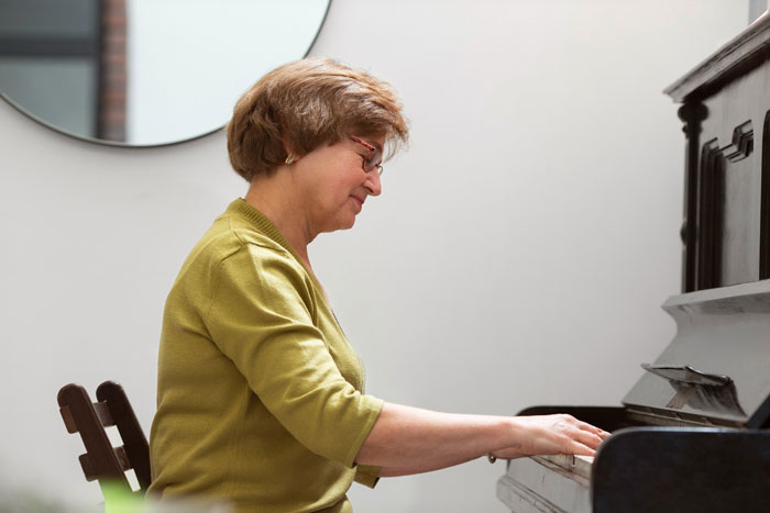 Woman playing an inherited piano at home after her parents donated the piano to church and she asked to take it back Woman playing an inherited piano at home after her parents donated the piano to church and she asked to take it back