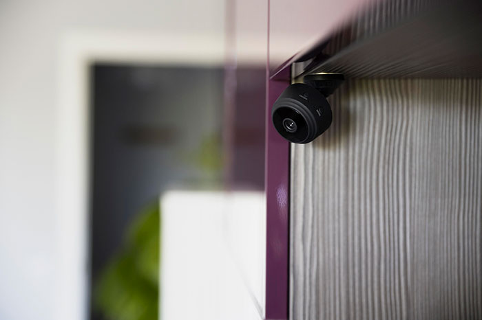 Small black security camera mounted on a wooden surface, symbolizing parents realizing their kids are monsters moments.