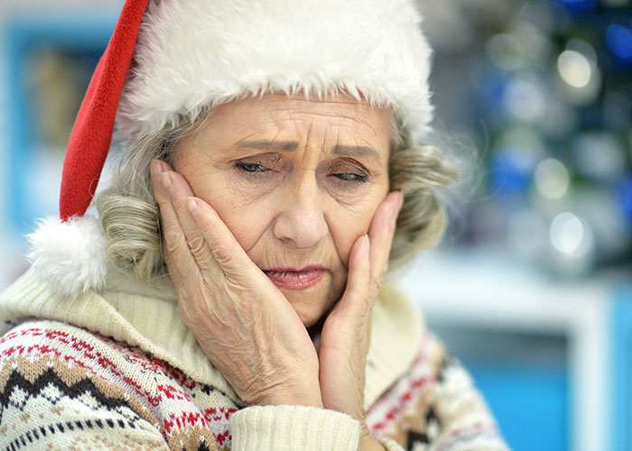 Elderly woman in a Santa hat looking upset and thoughtful, reflecting on son’s partner and gift issues. Elderly woman in a Santa hat looking upset and thoughtful, reflecting on son’s partner and gift issues.
