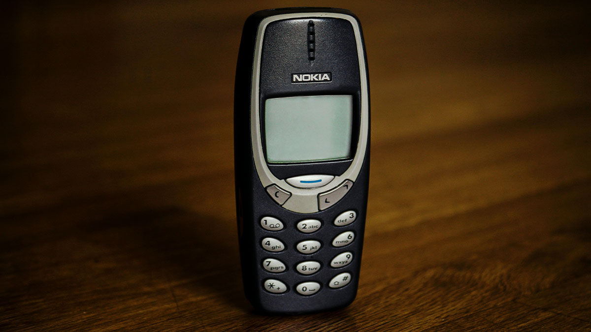 Vintage Nokia phone on wooden surface symbolizing secrets people trust strangers online with hidden connections.