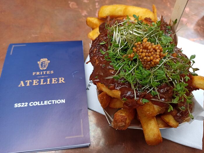 Fries topped with mustard seeds and fresh greens, showcasing a dish that didn’t need a gourmet upgrade.