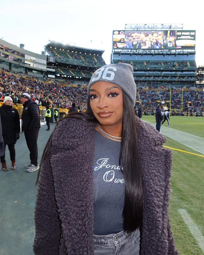 Simone Biles at stadium wearing gray beanie and coat, amid crowd, linked to controversy over dog with chopped-off ears. Simone Biles at stadium wearing gray beanie and coat, amid crowd, linked to controversy over dog with chopped-off ears.