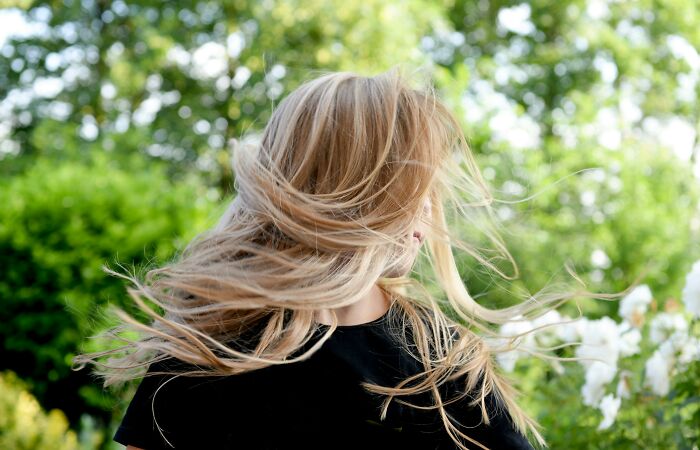 Blonde woman outside with hair blowing in the wind, illustrating people saying they’d rather not get horrible gifts.