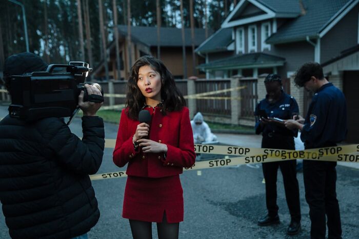 Reporter covering a disturbing scene behind police tape, capturing shocking facts people learned against their will.