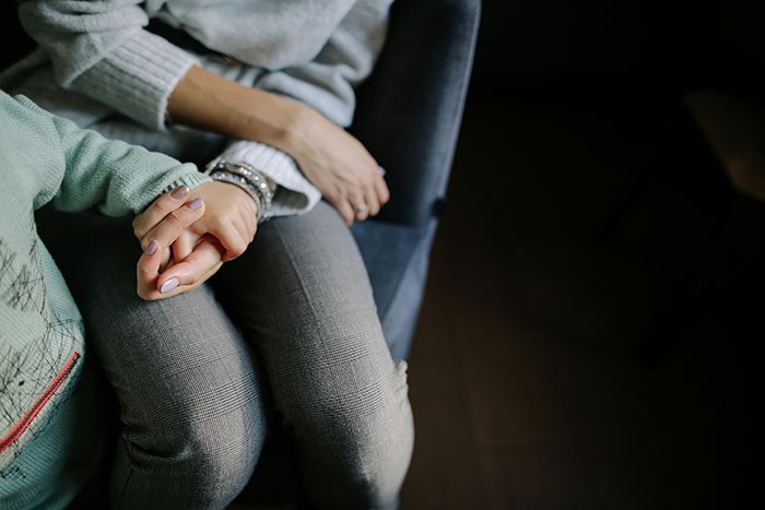 Teen and stepmother holding hands, capturing an emotional moment reflecting insecurity about a kid and family tension. Teen and stepmother holding hands, capturing an emotional moment reflecting insecurity about a kid and family tension.