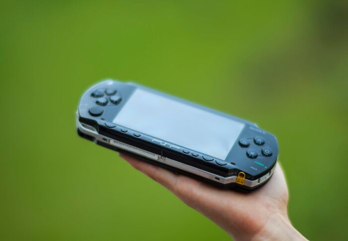 Hand holding an unusual personal belonging, a portable gaming console, found and never claimed at a lost and found.