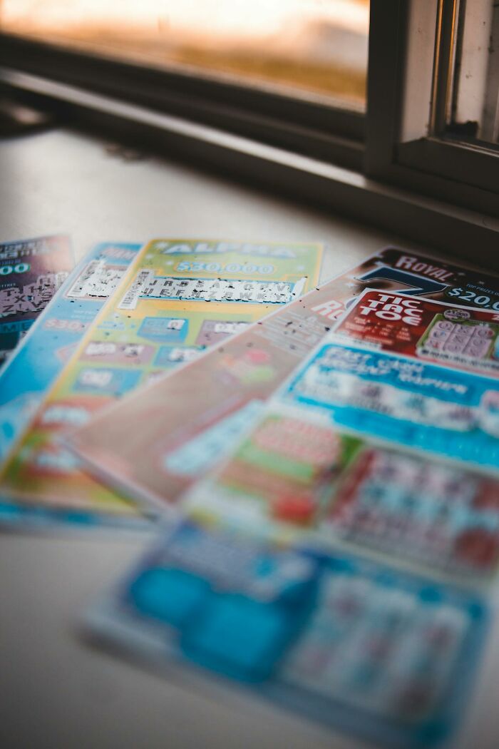 Scratch-off lottery tickets laid out on a windowsill, illustrating a glitch in the system and chance-based winnings.