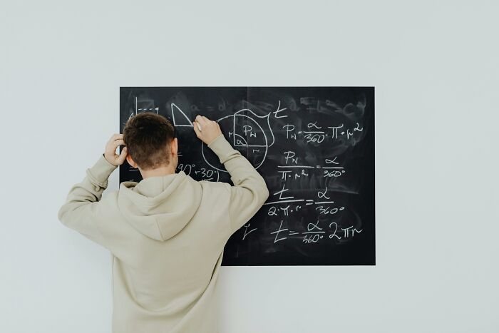 Student solving math problems on a blackboard, illustrating sharp math skills for an SAT quiz challenge. Student solving math problems on a blackboard, illustrating sharp math skills for an SAT quiz challenge.