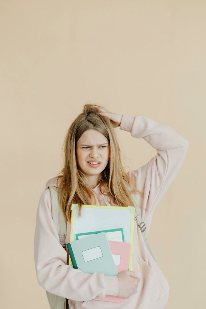 Teen girl with backpack and notebooks looking confused and frustrated, illustrating pure entitlement over gummy candies.