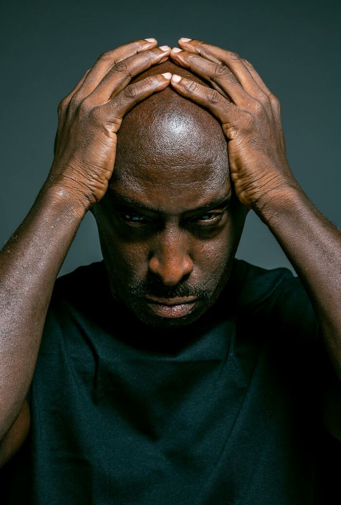 Stressed man holding his head, showing a disturbed expression representing disturbing facts people learned against their will.