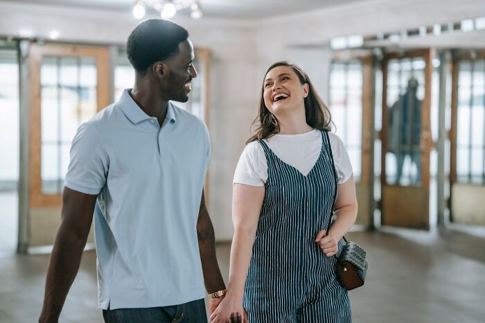 A happy couple laughing together indoors, capturing funny, clever and sassy moments in the heat of the moment.