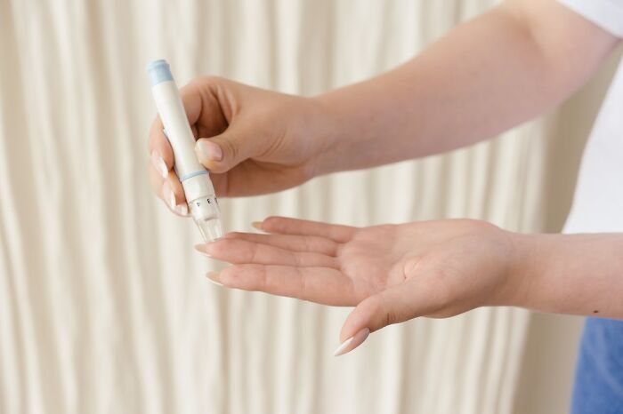 Person using a medical device on finger, showing unusual personal belonging found and never claimed at lost and found.