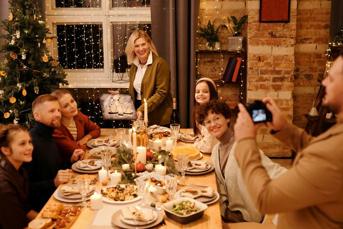 Family enjoying a festive dinner around a table with candles, food, and decorations, capturing unresolved mysteries moments.