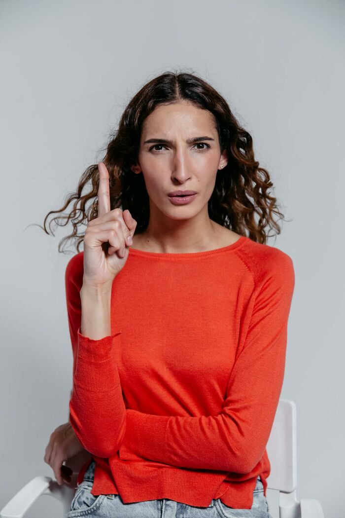 Woman displaying entitlement with a serious expression, raising finger as if throwing a fit over gummy candies.