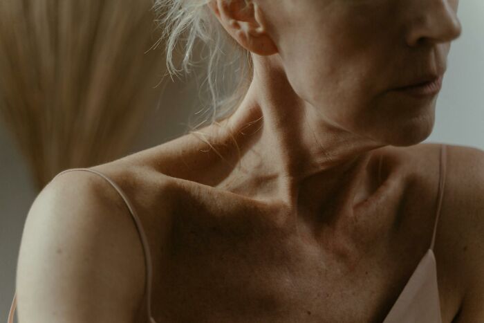 Close-up of a woman’s neck and shoulder with a pensive expression, evoking unresolved mysteries and chills.