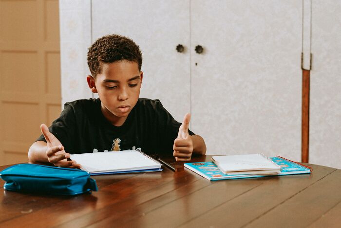 Boy studying math and science questions at a table, focused on beating the average 8th-grade student's level. Boy studying math and science questions at a table, focused on beating the average 8th-grade student's level.