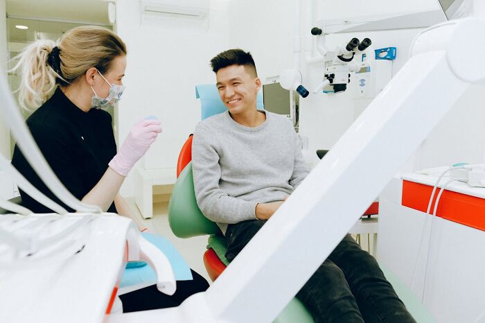 Dentist and patient smiling during a consultation, illustrating moments of pure entitlement over gummy candies.