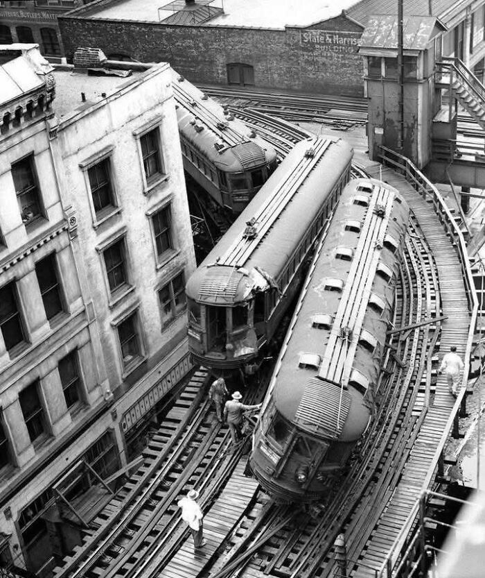 Historic black and white photo of vintage trains on curved tracks with workers nearby, a classic iconic historical picture.