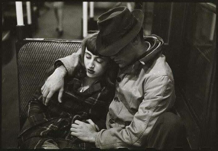 Black and white historical picture of a couple embracing on a bench, showcasing classic and iconic moments.