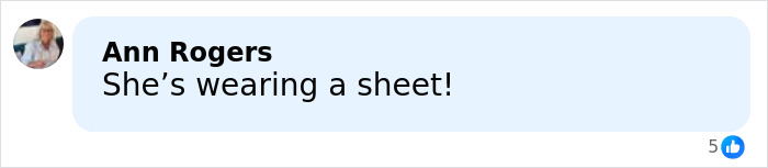 Comment saying she's wearing a satin bed sheet, reacting humorously to a wedding dress in an online discussion. Comment saying she's wearing a satin bed sheet, reacting humorously to a wedding dress in an online discussion.