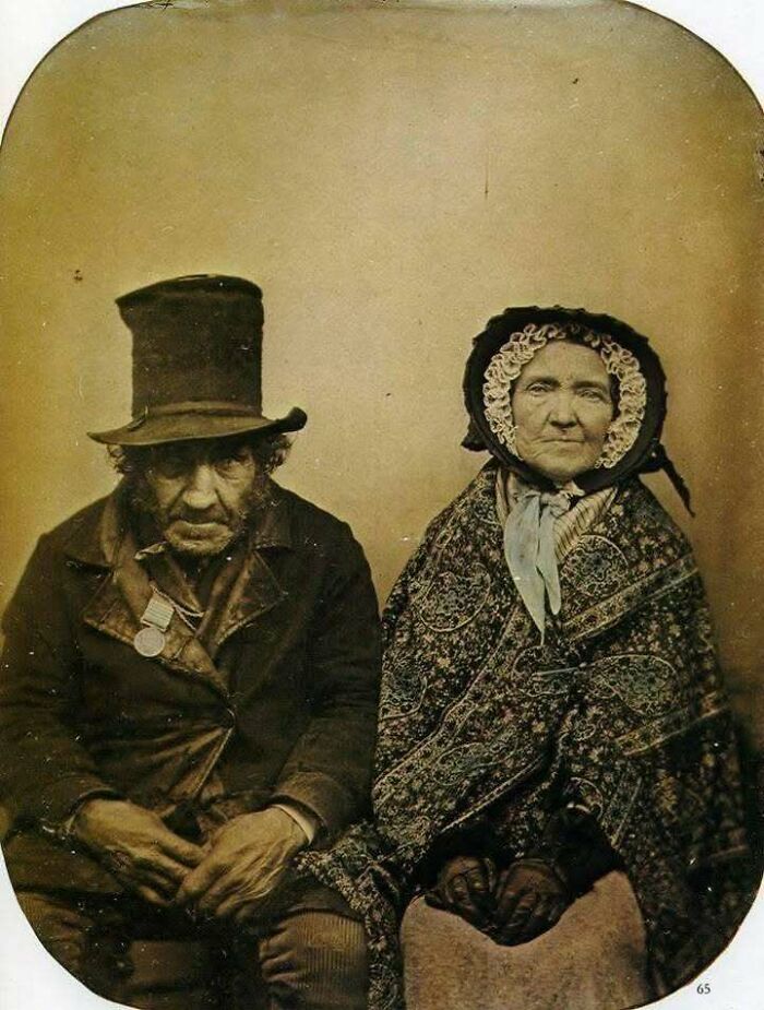Vintage portrait of an elderly man and woman dressed in 19th century attire, classic historical picture capturing iconic style.