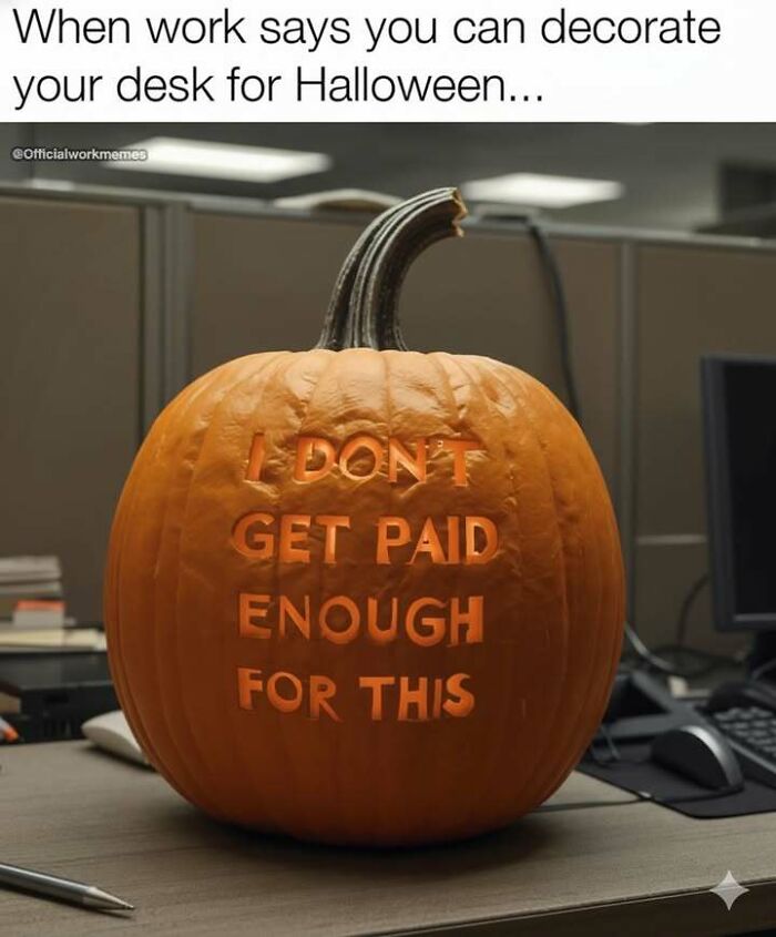 Carved Halloween pumpkin on office desk with humorous message about work pay, showcasing hilarious memes to relieve stress.
