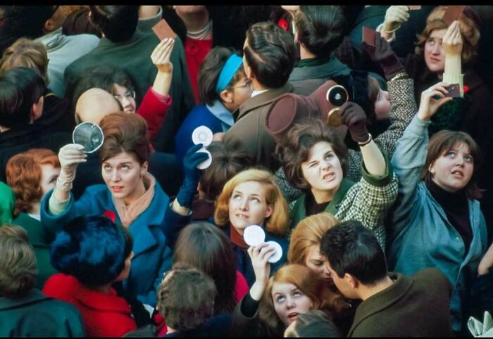 Crowd of people holding up historic tintype photographs, capturing a classic and iconic moment in history.