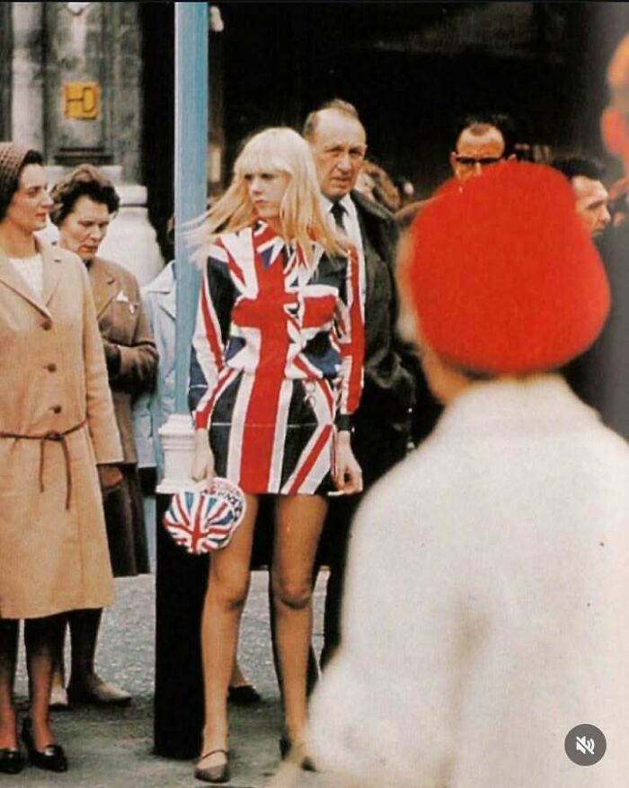 Young woman in 1960s mod style wearing Union Jack dress and handbag, captured in a classic, iconic historical picture.