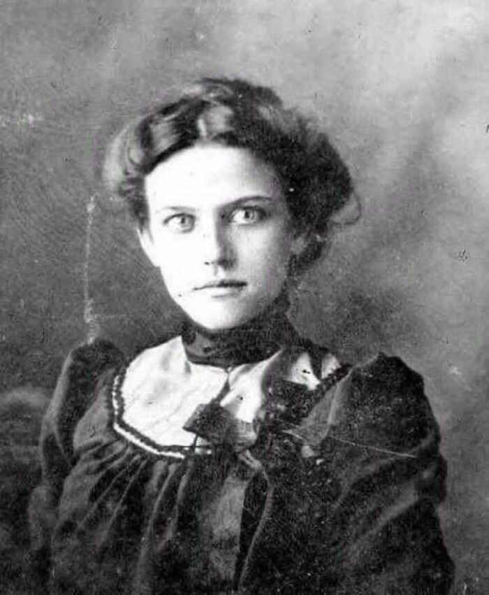 Black and white historical picture of a woman with intense eyes wearing vintage Victorian-style clothing.