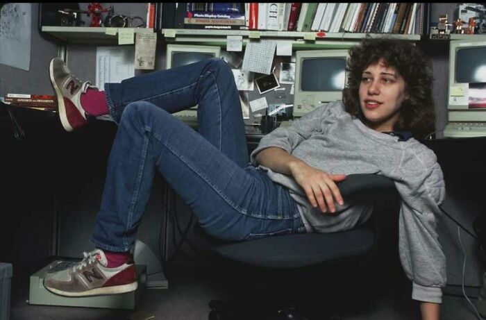 Young person relaxing in a vintage office surrounded by old computers, capturing a classic and iconic historical moment.
