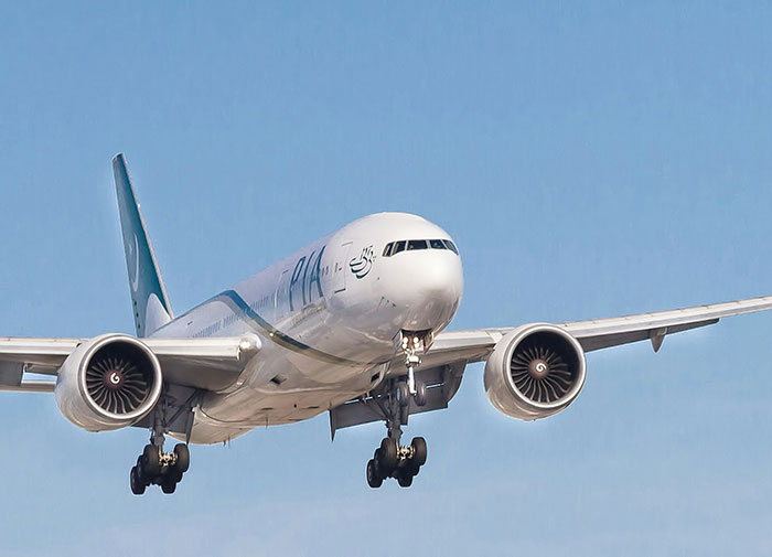 Commercial airplane approaching for landing under clear blue sky, related to woman breaking down in tears on flight.