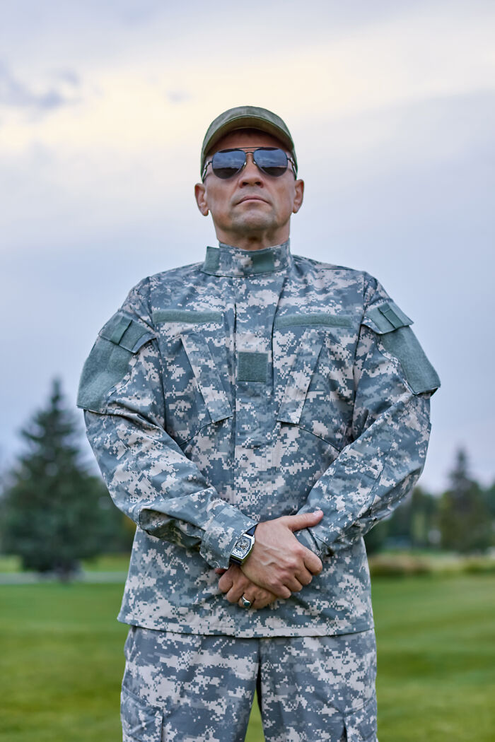 Man in digital camouflage military uniform and sunglasses standing outdoors representing incredible minds and genius without a degree