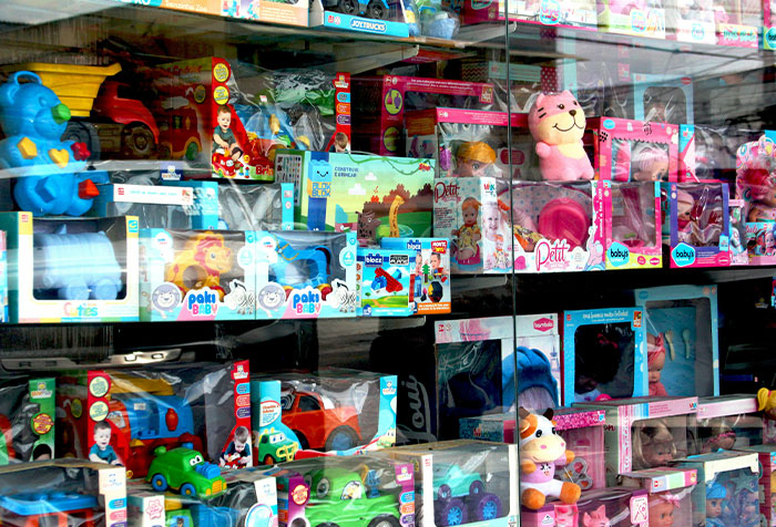 Toy store display with various colorful dolls and vehicles, highlighting women's microfeminism against toxic masculinity.