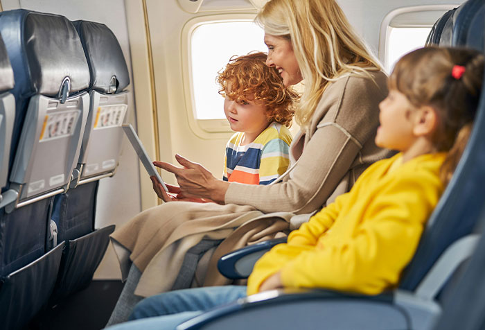 Woman engaging with children on a plane, illustrating microfeminism and women standing against toxic masculinity.