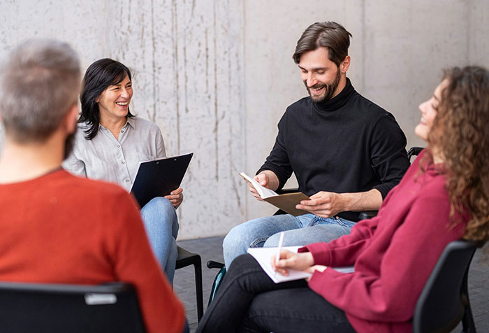 Group of diverse women and men engaged in a discussion, representing acts of microfeminism clapping back at toxic masculinity.