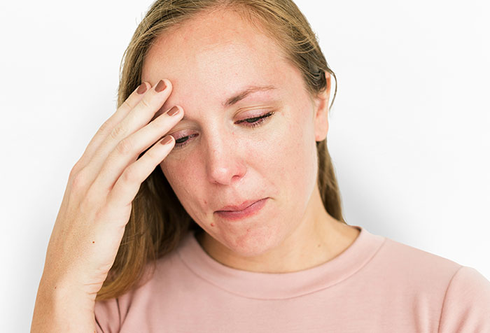 Woman in a pink shirt showing emotional frustration, representing women clapping back at toxic masculinity with microfeminism.
