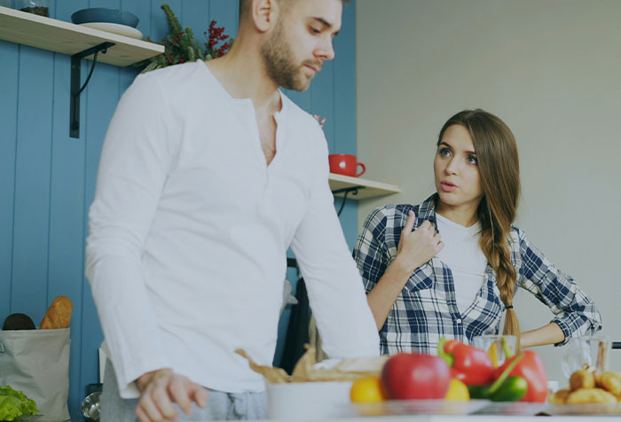 Woman clapping back at toxic masculinity during a kitchen conversation, embodying microfeminism with confidence and assertiveness.
