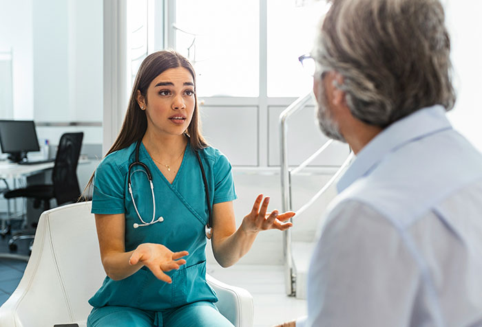 Young woman in medical scrubs engaging in a serious conversation, symbolizing women clapping back at toxic masculinity.