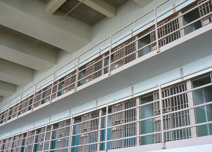 Interior view of prison cells with barred doors and metal railings illustrating prison life and common misconceptions.