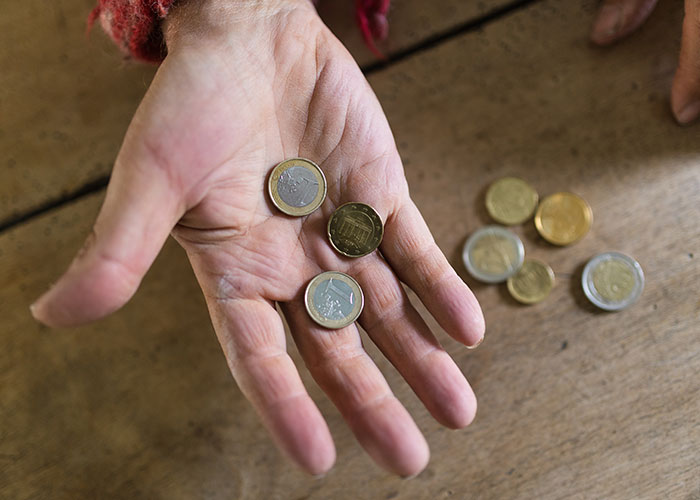 Close-up of hand holding coins, illustrating surprising facts and misconceptions about prison life shared by inmates.