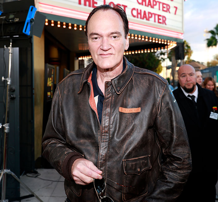 Quentin Tarantino wearing a leather jacket at a film premiere, related to weakest male actor controversy in Hollywood.