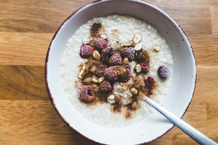 Bowl of oatmeal topped with frozen berries and nuts, highlighting common habits affecting long-term health.