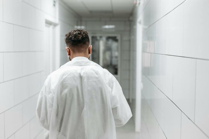 Man in white coat walking down sterile hallway, symbolizing wild stories from folks who quit their jobs fast.