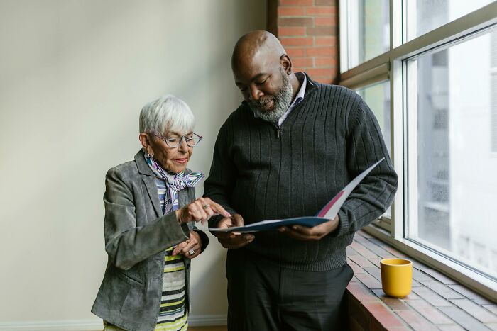 Two professionals reviewing documents by a window, illustrating stories of quitting jobs in record time and reasons why.