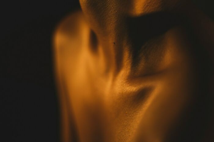 Close-up of a human neck and shoulder with warm lighting illustrating surprising facts that sound made up but are true.