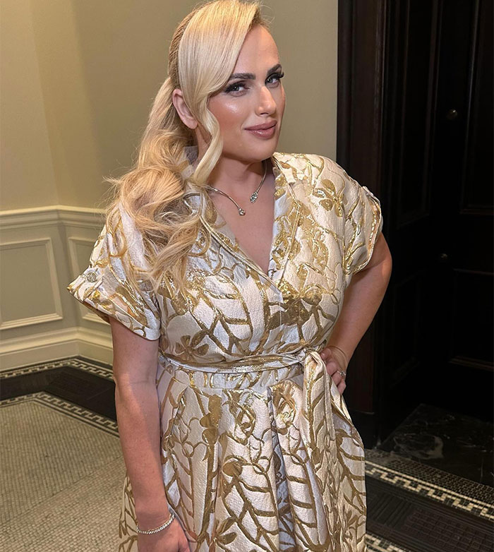 Rebel Wilson posing indoors in a shiny gold patterned dress, drawing attention to a bizarre detail noticed by people. Rebel Wilson posing indoors in a shiny gold patterned dress, drawing attention to a bizarre detail noticed by people.