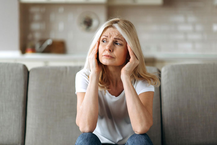 Woman sitting on sofa looking worried and stressed, reflecting on refuse taking care granddaughter free situation. Woman sitting on sofa looking worried and stressed, reflecting on refuse taking care granddaughter free situation.