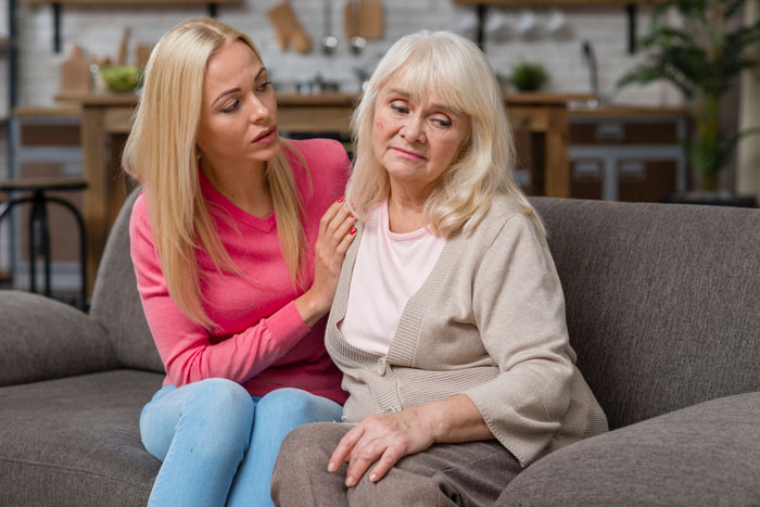 Elderly woman refusing to take care of granddaughter, showing a tense conversation on a living room couch. Elderly woman refusing to take care of granddaughter, showing a tense conversation on a living room couch.